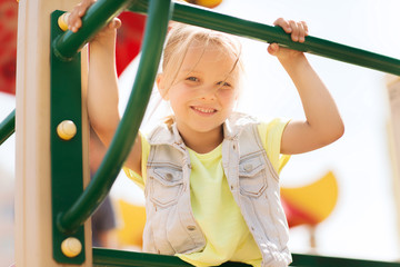 happy little girl climbing on children playground