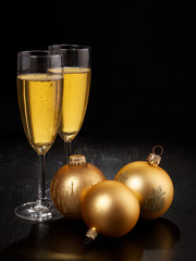 Champagne flutes and Christmas decorations on dark background