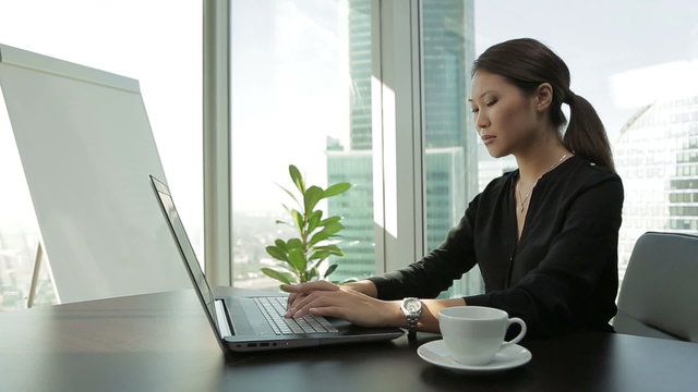 young Asian Business woman at office with laptop, typing, Dolly