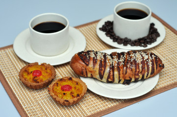 red bean bread and coconut tart on bamboo mat with hot coffee