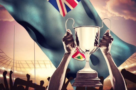 Composite image of cropped hand of athlete holding trophy - Powered by Adobe