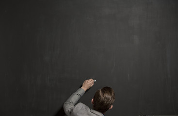 empty chalk black board with chalk in the hand