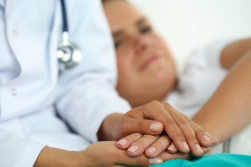 Obraz premium Friendly female doctor hands holding patient hand