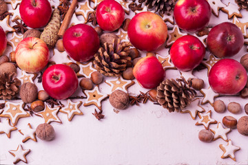 Christmas background. Gingerbread cookies, apples, spices and nu