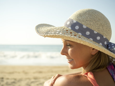 happy girl smiling portrait in the beach  a picture hat with the sea and horizon in the background