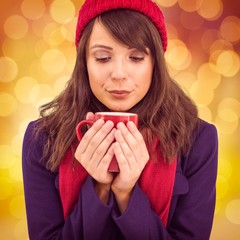 Composite image of festive brunette holding a mug