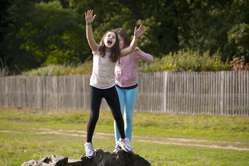 Be Sure to Sparkle. Two girls are pretending to push each other off a log. It is a game they made...