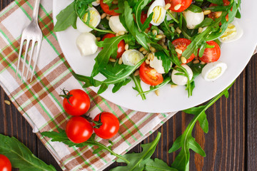 Salad with arugula on a wooden background