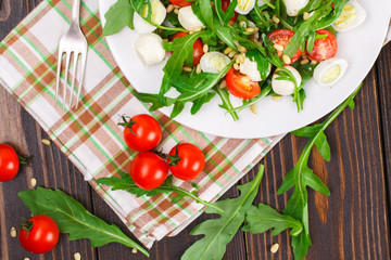 Salad with arugula on a wooden background