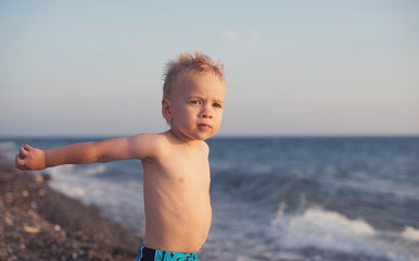 Boy throw the hand on the beach