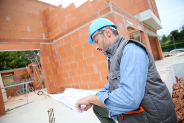 Fototapeta premium Construction manager checking blueprint on site