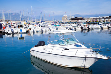 Fototapeta premium White motor-boat floats moored in marina
