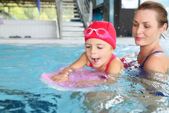 Mother and daughter training at the swimming-pool