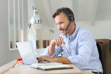 Businessman teleworking, headset on