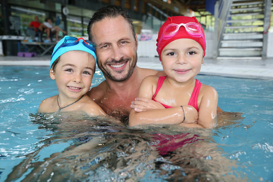Man with kids in public swimming-pool