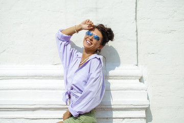 Fashion portrait of young brunette model posing by the wall