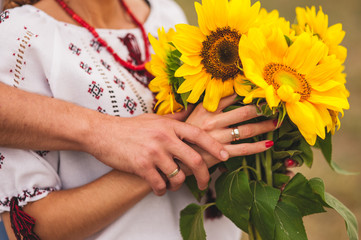 man and woman  holding a bouquet of sunflowers. ukrainian wedding