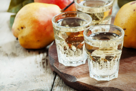 Pear fizzy drink, soda in a glass and fresh pears on a wooden ba