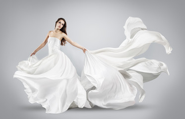 Fototapeta na wymiar beautiful young girl in flying white dress. Flowing fabric