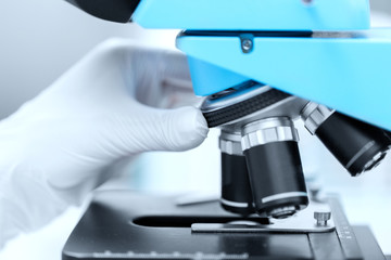 close up of scientist hand setting microscope