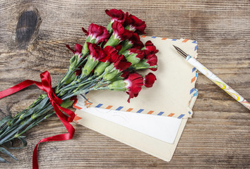 Set of old letters and bouquet of red carnation flowers