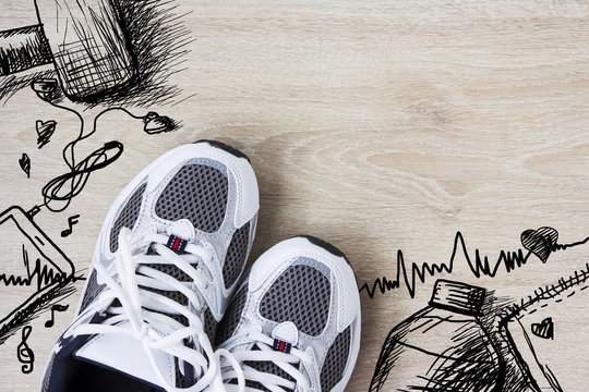Sport shoes and hand drawn design on the wooden floor. Healthy c