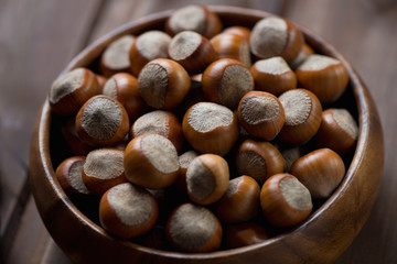 Close-up of hazelnuts in a wooden bowl, selective focus