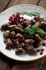 Roasted chicken hearts with pomegranate seeds, close-up