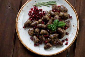 Top view of roasted chicken hearts with pomegranate, studio shot