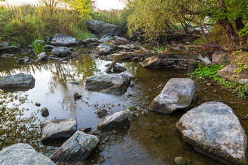 Stone rapids on the river in the rays of sunrise.