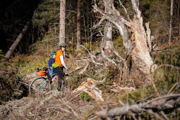 Bikers travel in difficult conditions in autumn forest