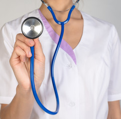 Woman doctor in a lab coat holding a stethoscope