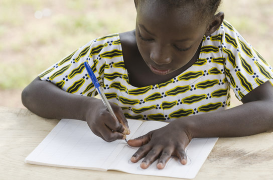 Black African Girl drawing and writing in her workbook in an African school in Bamako, Mali. Educational symbol for Africa.