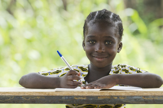 Young African Schoolgirl Writing Doing her Homework