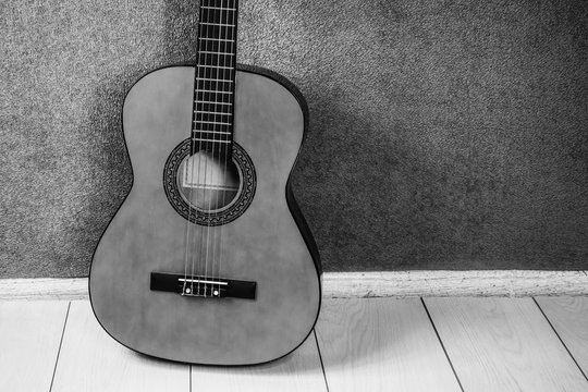 string guitar on the floor near the wall