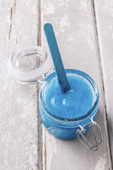 Blue body scrub on wooden table
