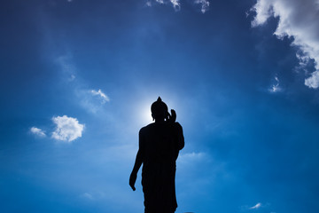 Buddha statue ok sign post bottom view with dark silhouette with