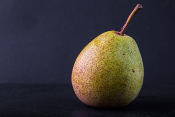 One pear on black background