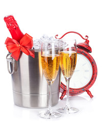 Two champagne glasses, bottle in cooler and clock