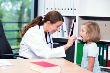 Obraz premium female pediatrician in white lab coat examined little patient