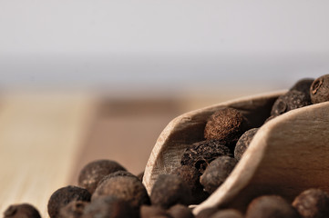 Grains allspice on a wooden board.
