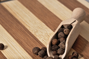 Grains allspice on a wooden board.
