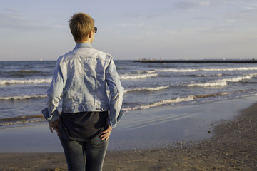 Mujer en la playa esperando y mirando al horizonte