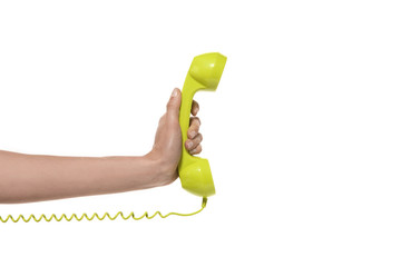 emergency phone call - hand holding yellow-green landline phone - isolated on white.