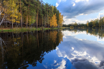 Fototapeta na wymiar golden autumn, birches' reflection in the water, trees reflection in the river on sunrise, golden fall sunrise in forest