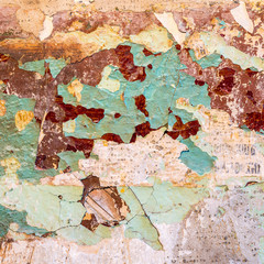 Old wall texture - peeling teal and maroon paint, some plaster and tattered newspaper (fragments of...