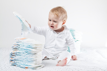 Baby hält eine Windel in der Hand