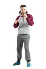 Young sporty casual man in sportswear with boxing hand gesture isolated