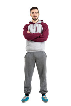 Young happy bearded casual man in sportswear with crossed hands isolated 