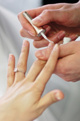 Applying of the french nail at the beauty salon. 